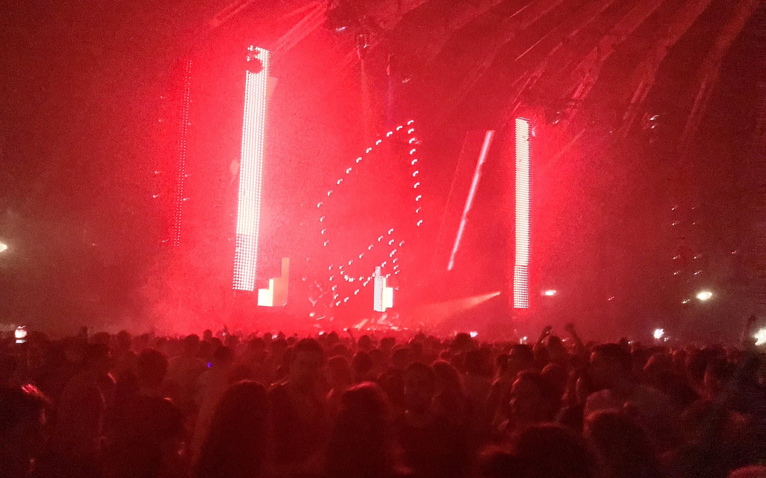 Escenario de techno con luces rojas y público (imagen ilustrativa)