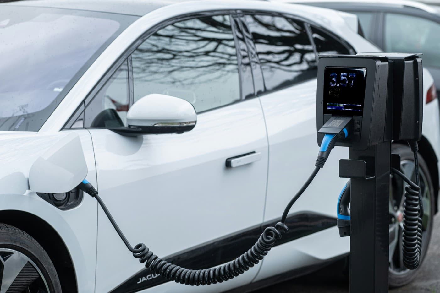An electric car plugged into a charging point, as an emissions reduction measure
