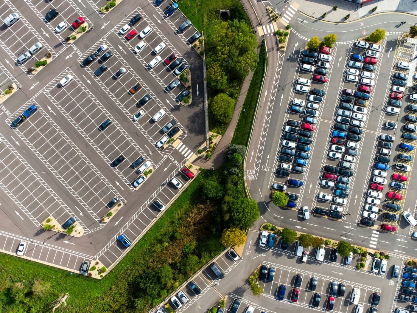 Aerial view of a large venue's parking area with a car park access sign